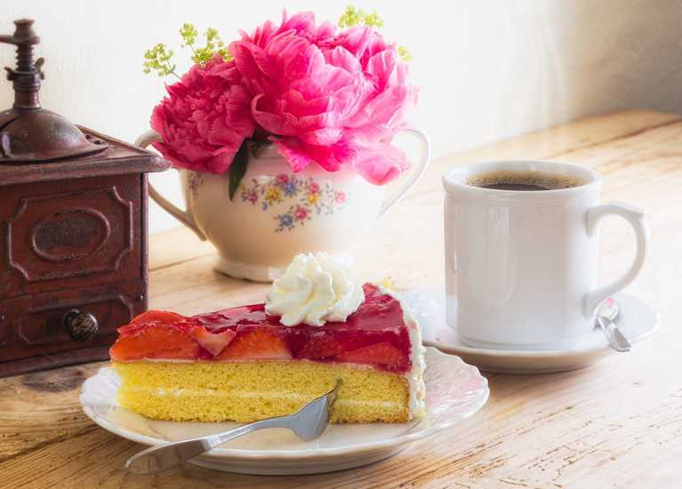 leckere Erdbeertorte und eine Tasse Kaffee im Hofcafé serviert